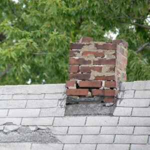 a damaged masonry chimney on a gay roof