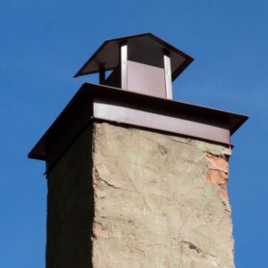 a chimney with a chase cover and a pointed, roof-like chimney cap