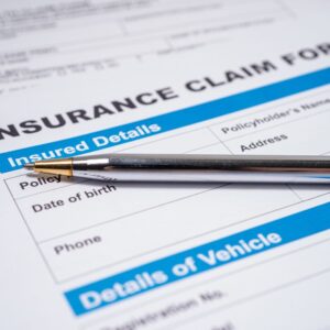 an insurance claim form with a pen on top of it