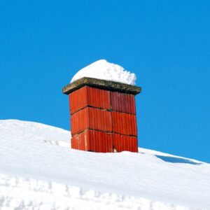 a red chimney with snow on it on a snowy roof