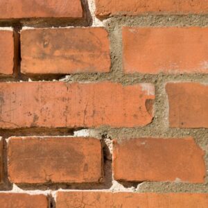 a close up of a brick wall with mortar missing and chips