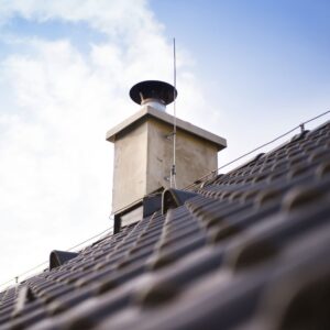 a concrete chimney with a chimney chase cover and a chimney cap